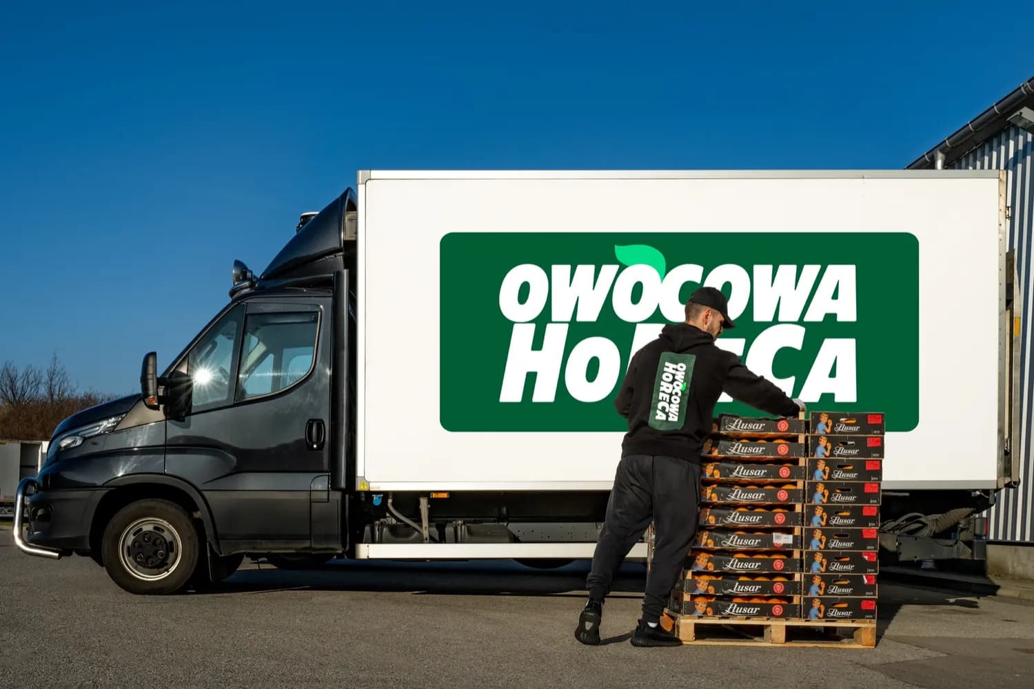 Załadunek skrzynek z owocami i warzywami do busa Owocowa HoReCa